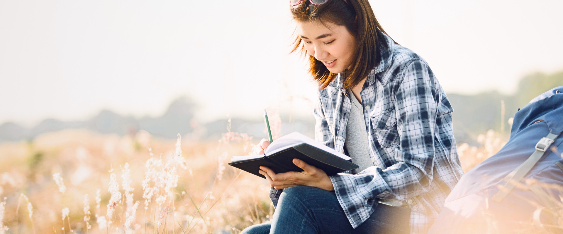 Woman journaling in a peaceful outdoor setting, reflecting on Bible verses using the 3C Bible Journaling method.