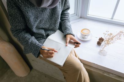 Woman quietly reflecting and journaling, contemplating the meaning of Scripture in her life.